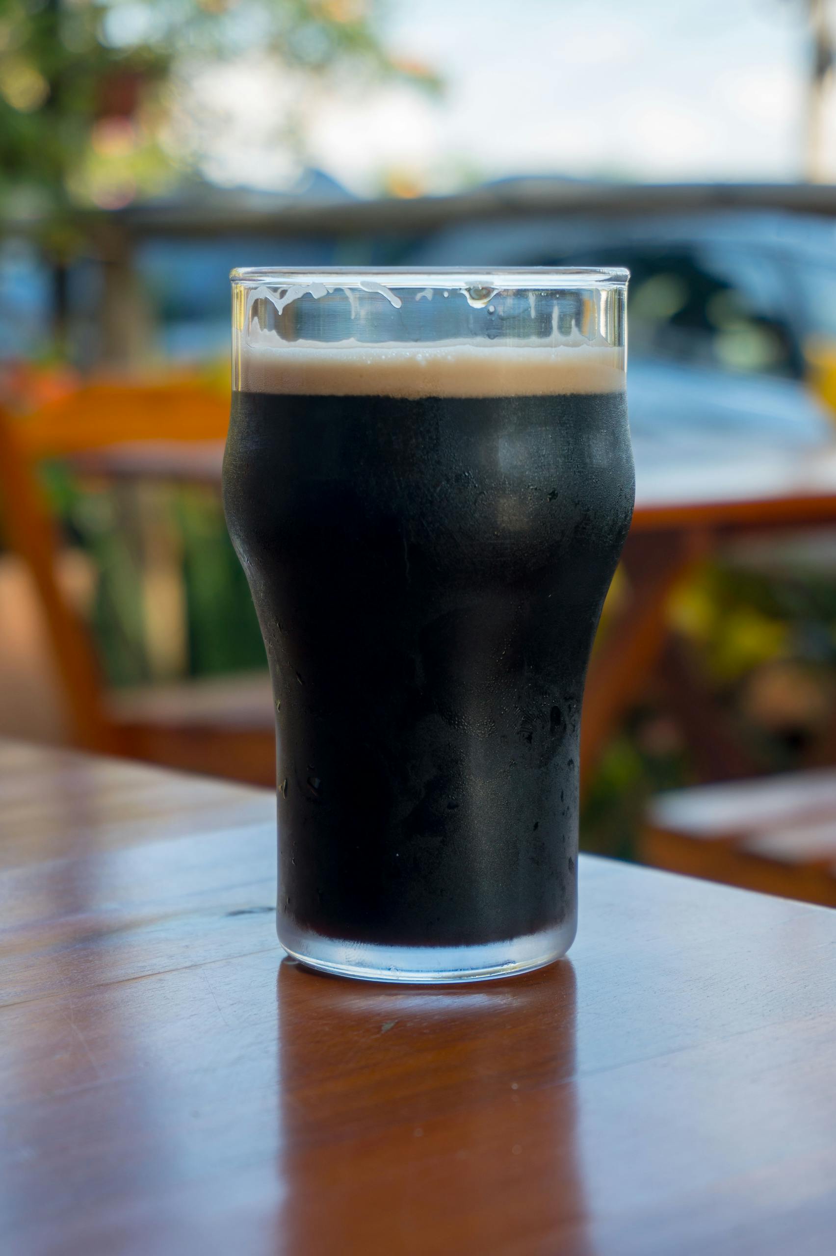Close-up of a dark beer in a glass on a sunny day in Holambra, Brazil.
